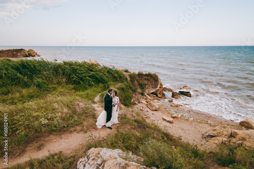 Groom and bride on a walk outdoors near the water