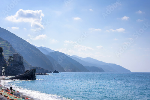 Beautiful daylight view to blue sea and green mountains in fog. Monterosso al Mare, Italy. Cinque Terre