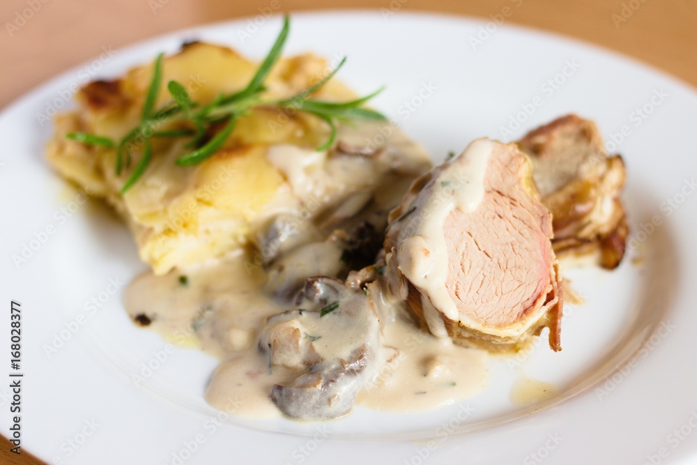 Pork tenderloin in bacon with potatoes and mushroom sauce Pork tenderloin in bacon with potatoes and mushroom sauce