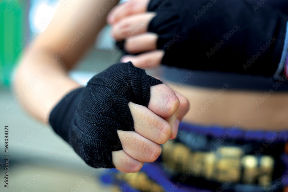 Closed up of Thai woman boxing punch with black bandage.