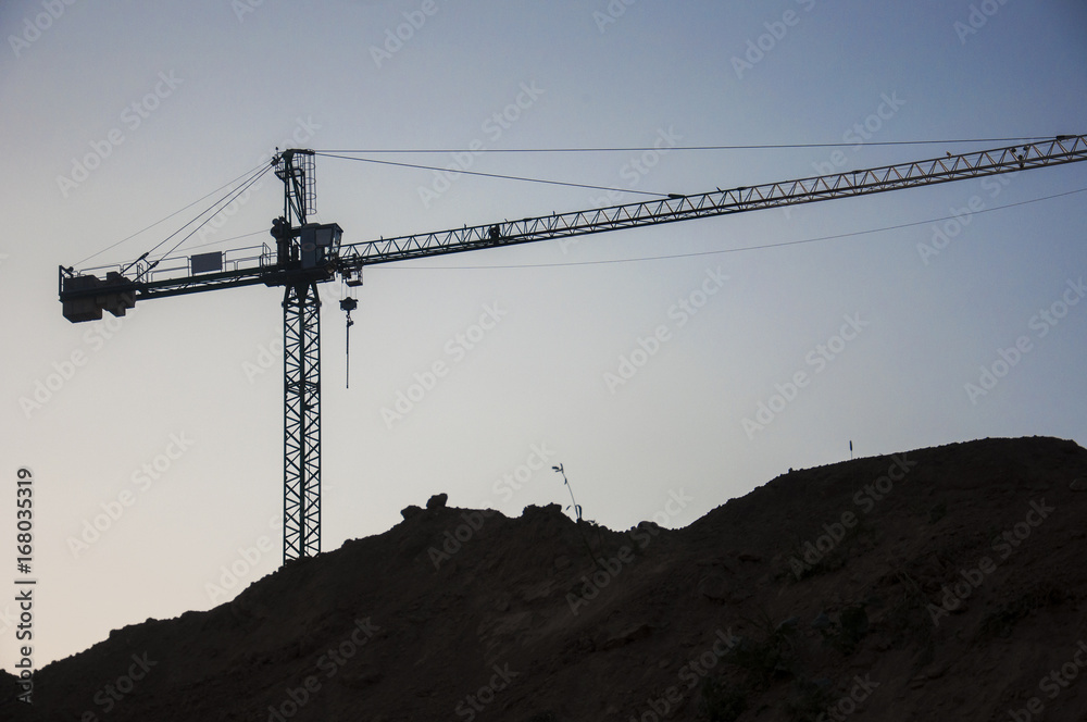 a crane on construction site at sunset