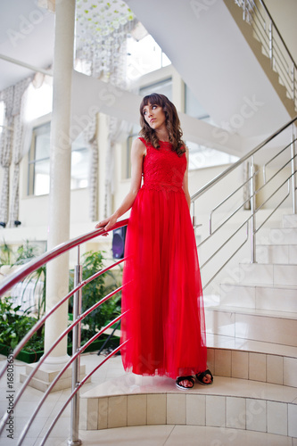 Portrait of a beautiful girl in fashionable designer clothes posing on the fly of stairs in the hotel or in the restaurant. © AS Photo Family