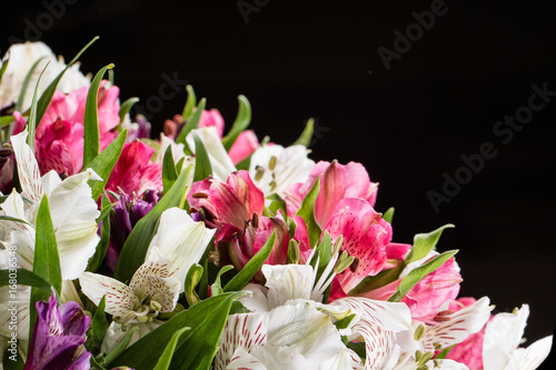 Bouquet of pink and white irises on a black background