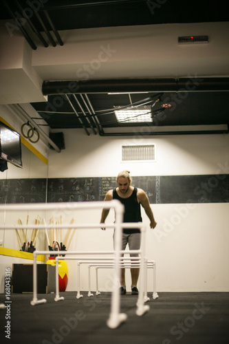 Young man jumping over obstacles in gym. Man in the gym. © liderina