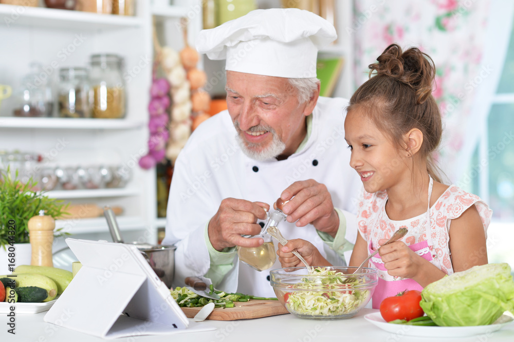 man preparing dinner with granddaughter man preparing dinner with granddaughter