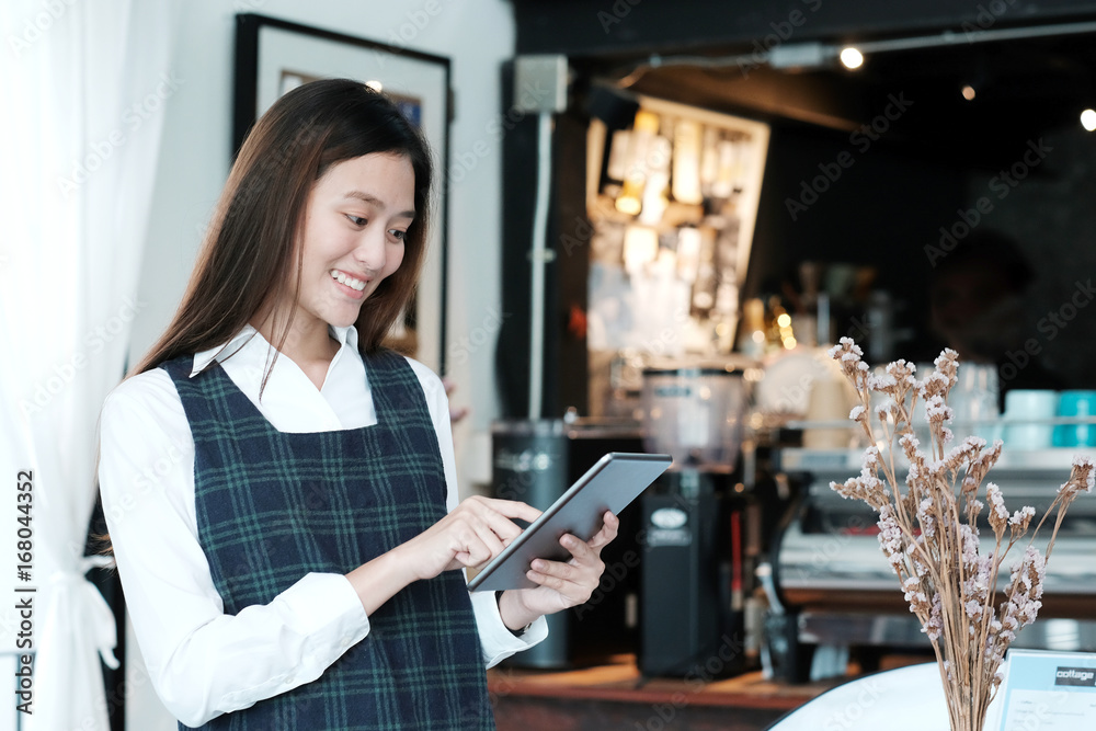 Young asian woman using tablet at cafe background, food and drink concept