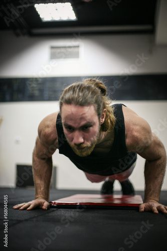 Young man doing push-ups in the gym. Man workout i gym.