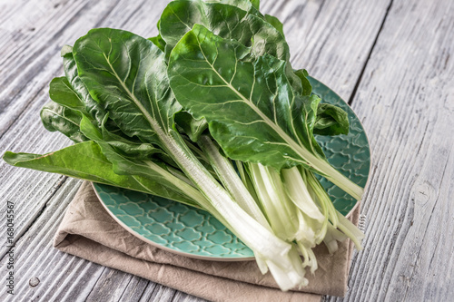 Fotografia Fresh organic chard on a rustic background