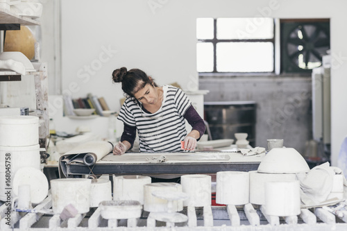 Female ceramic artist working on a sheet of clay
