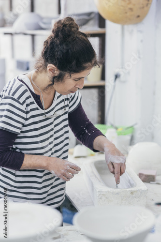Female ceramic artist working on a mould