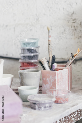 Ceramic cups, painting brushes and colouring material in a studio