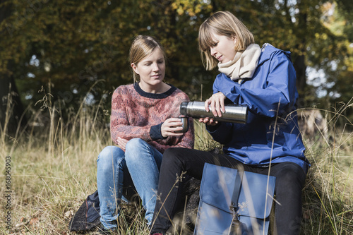 Two woman enjoying a hot drink in the forest