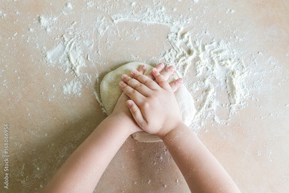Fototapeta premium Children's hands make dough