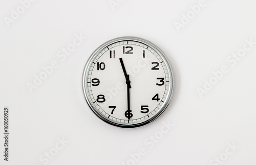 White Clock hanging on a white wall showing time 11:30