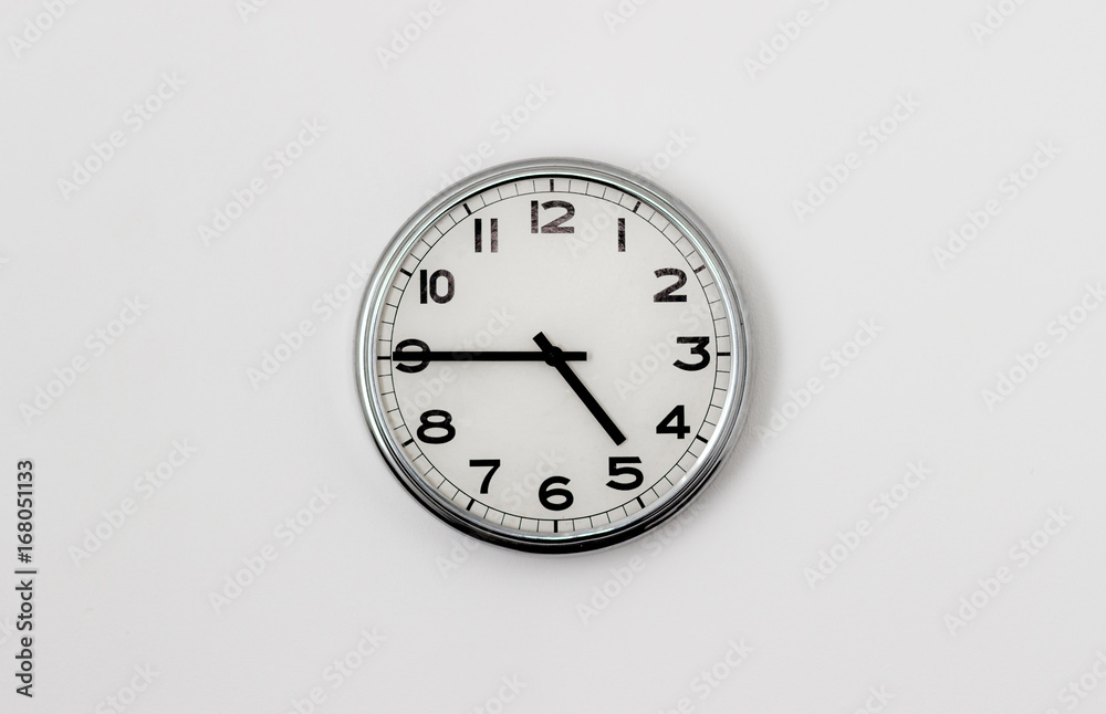 White Clock hanging on a white wall showing time 4:45 White Clock hanging on a white wall showing time 4:45