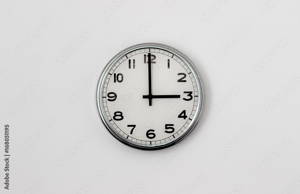 White Clock hanging on a white wall showing time 3:00 White Clock hanging on a white wall showing time 3:00