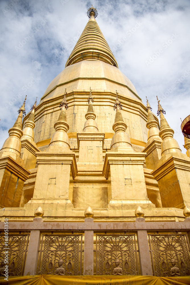 Large golden temple with sky background, Name is Phra Maha Chedi Srivang Chai, Located in Lamphun, Thailand.
