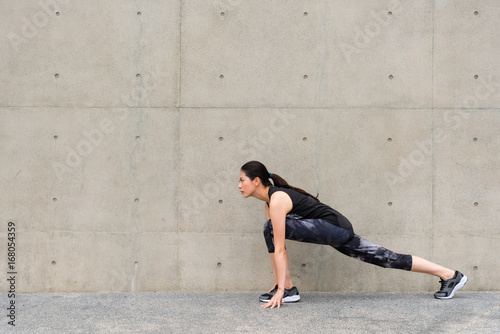 beautiful runner woman stretching legs with lunge