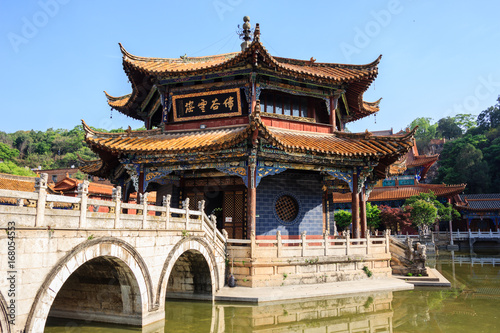 Traditional Chinese Buddhist Confucius temple with a stone bridge and pond