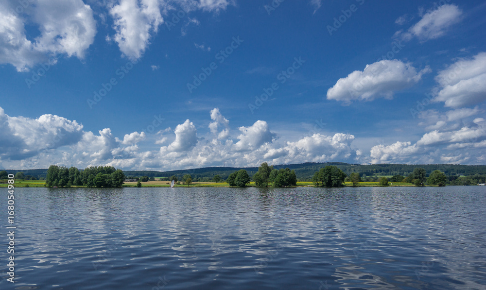 See und Himmel mit Wolken. Wunderschön, wie sich die Landschaft im Wasser spiegelt See und Himmel mit Wolken. Wunderschön, wie sich die Landschaft im Wasser spiegelt