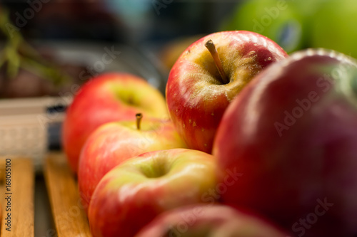 Group of ripe red apples on wooden tray