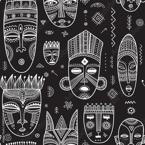 Vector seamless pattern with African ethnic tribal masks decorated with boho ornaments and ritual symbols.