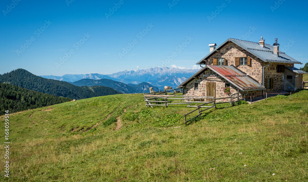 view of alpine mountain scenary with traditional old mountain chalet on a summer day. Dolomites mountains, South Tyrol, Italy