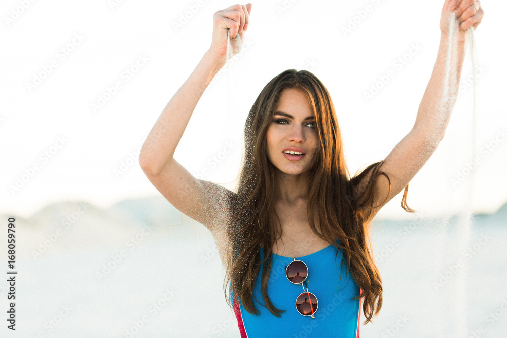 Woman plays with sand on the beach Woman plays with sand on the beach