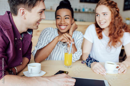 multiethnic friends talking in cafe