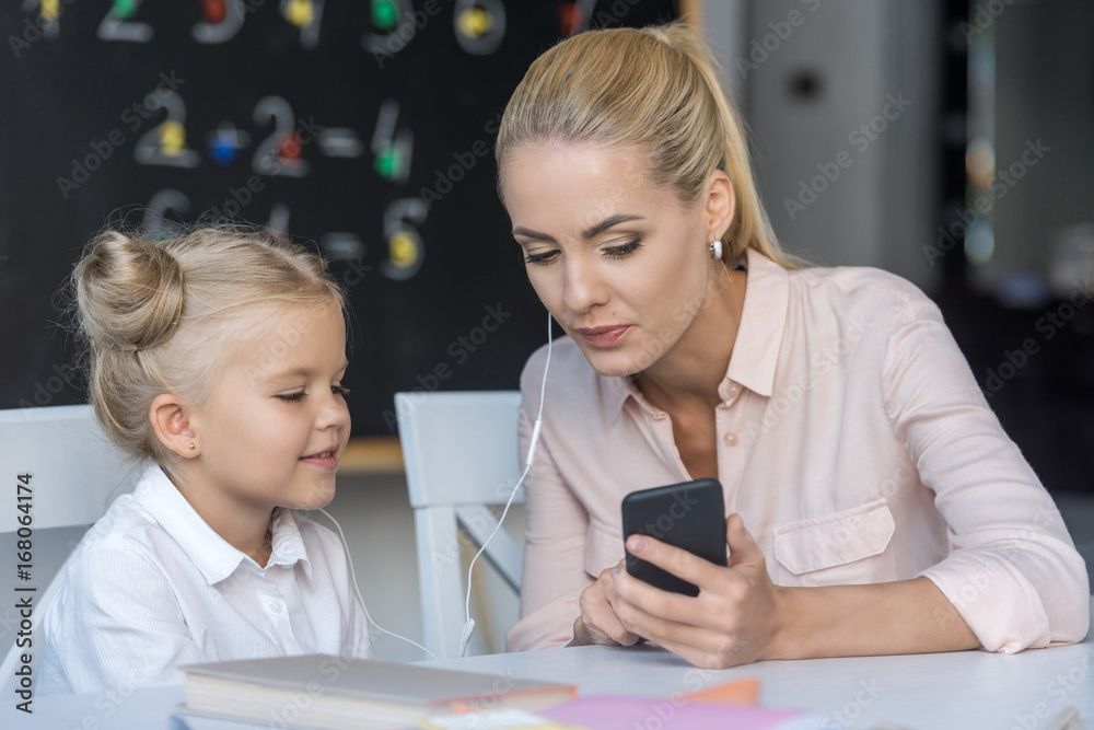 mother and daughter using smartphone mother and daughter using smartphone