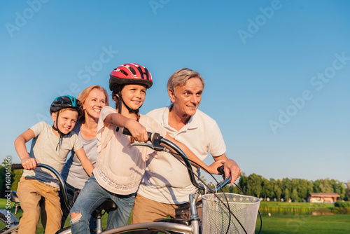 grandparents helping children ride bicycle