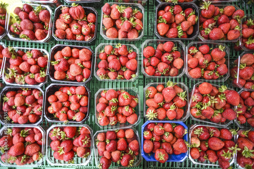 Strawberries in baskets, sold at a local vegetable market during the summer season. Strawberries in baskets, sold at a local vegetable market during the summer season.