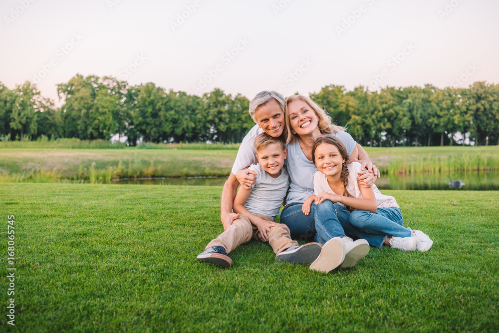 family resting on meadow