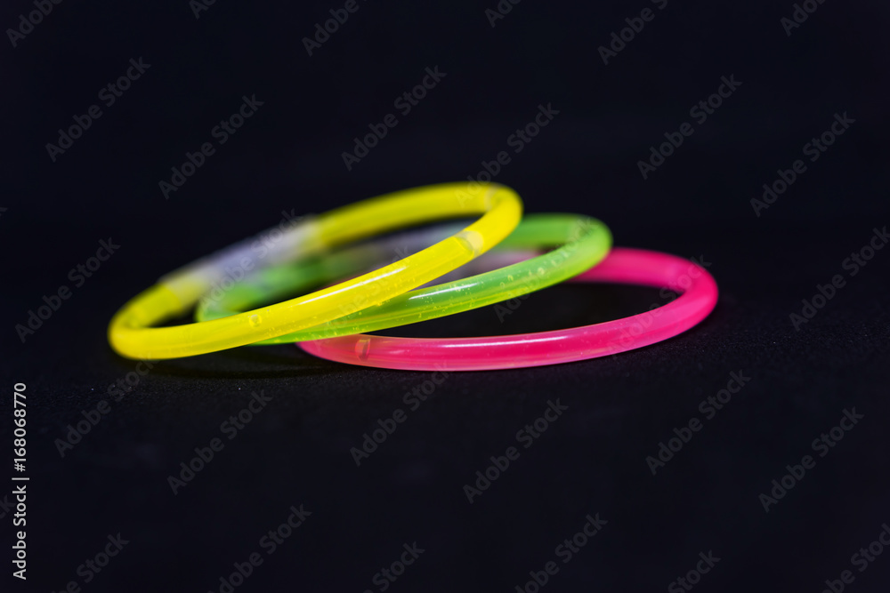 Trendy color, neon bracelets, on black background. Beuty fashion concept. Shallow depth of focus. Trendy color, neon bracelets, on black background. Beuty fashion concept. Shallow depth of focus.