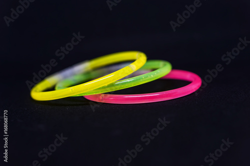 Trendy color, neon bracelets, on black background. Beuty fashion concept. Shallow depth of focus.