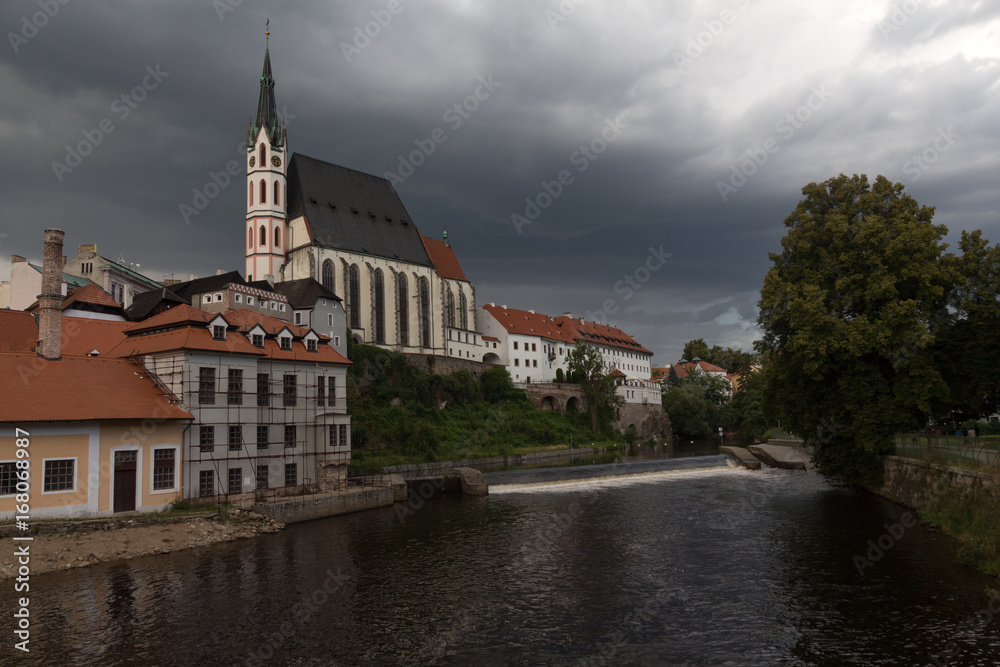 Heavy clouds over the red roofs af chehien town Cheski-Krumlov