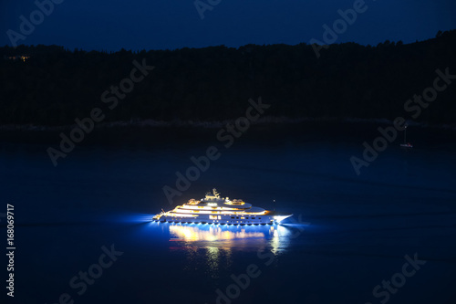 An illuminated luxury yacht in the Adriatiac sea at night in Dalmatia, Croatia. © Goran Jakus