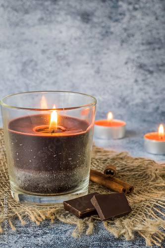  Decorative candles with the aroma of chocolate and cinnamon on a dark blue background.