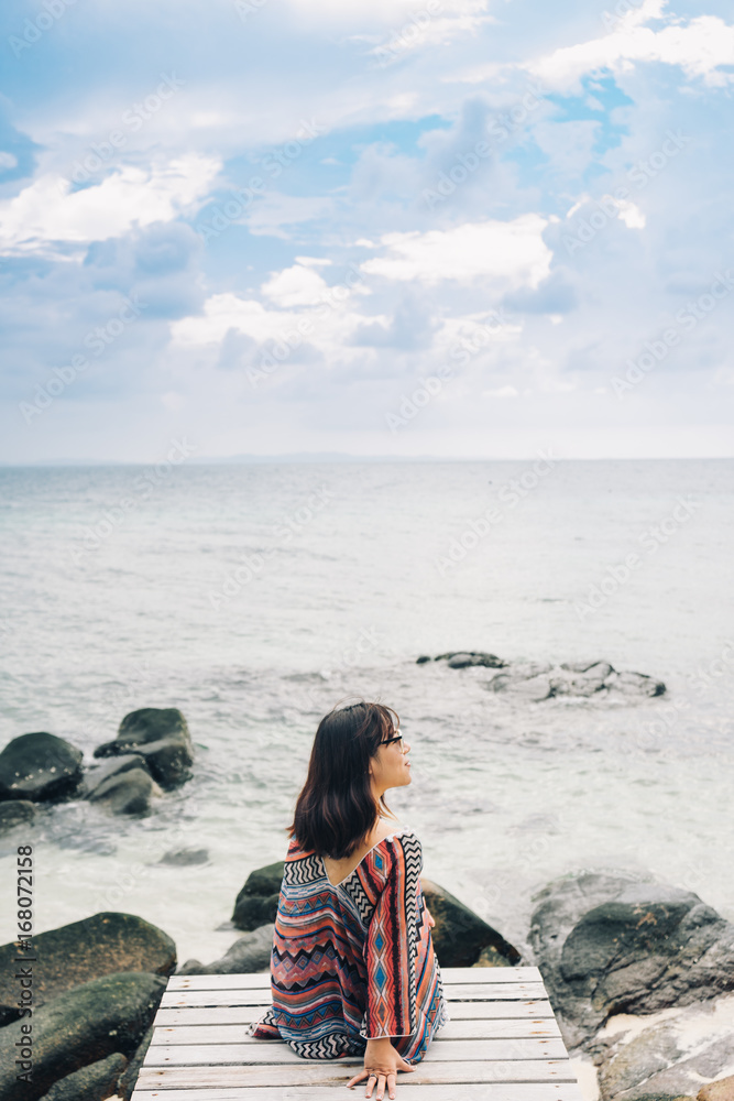 The beautiful woman sitting on the wooden bridge near the beach in Koh munnork island, Thailand. The beautiful woman sitting on the wooden bridge near the beach in Koh munnork island, Thailand.