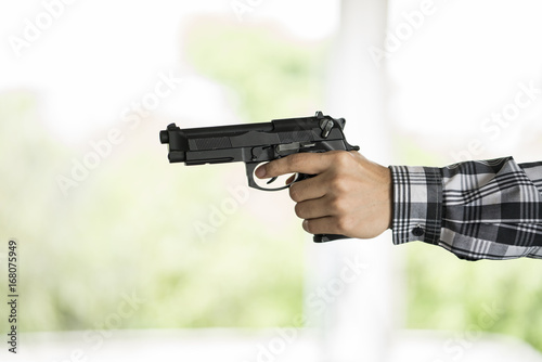 Hand of terrorist holding a gun