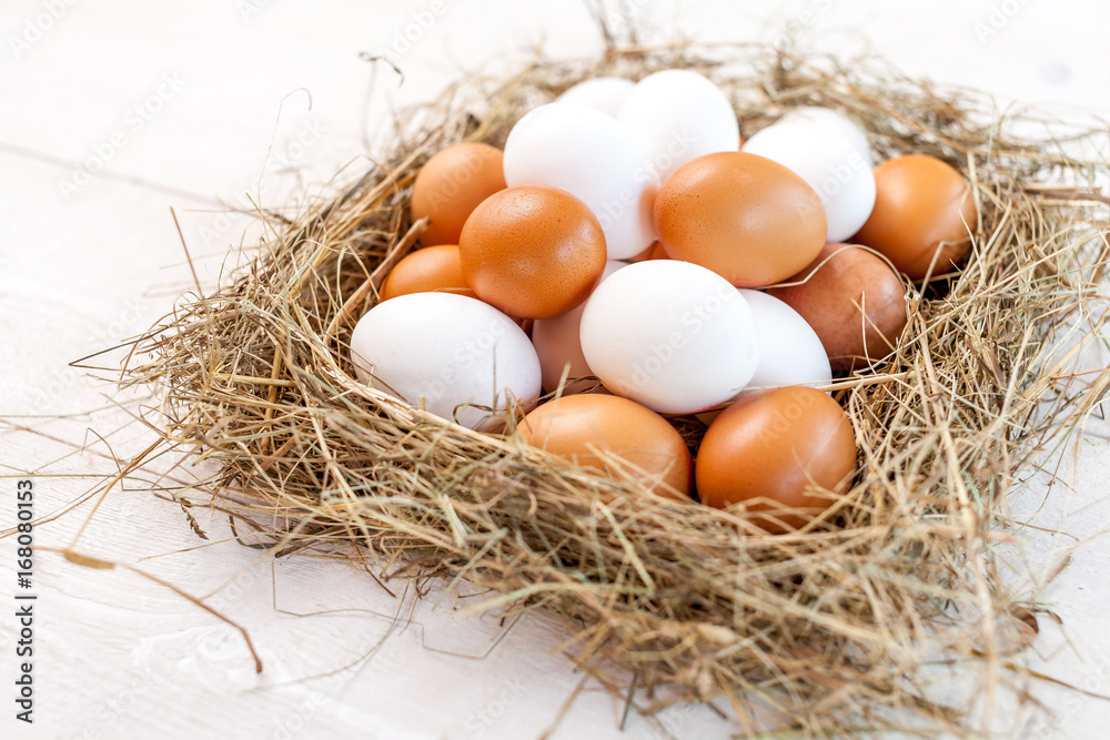 Fresh country eggs with straw on rustic wooden white table Fresh country eggs with straw on rustic wooden white table