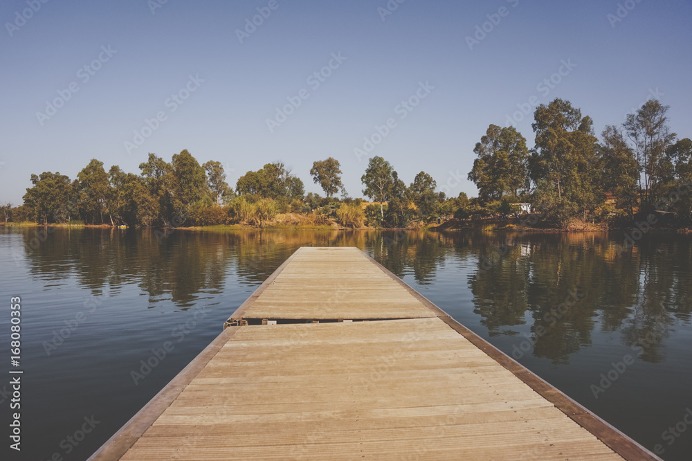 wooden pier on big lake surrounded by trees