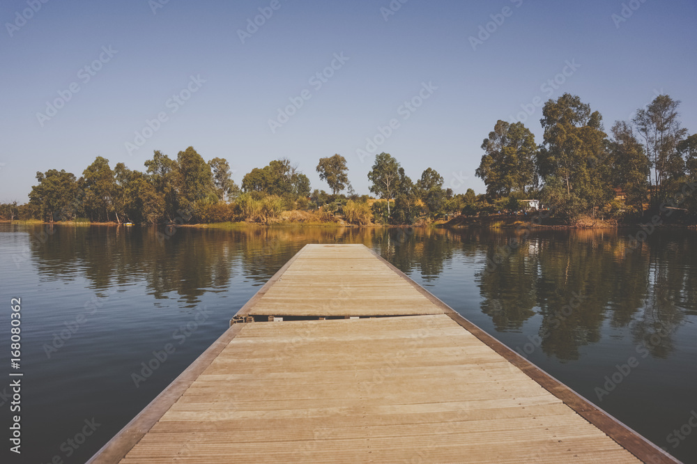wooden pier on big lake surrounded by trees