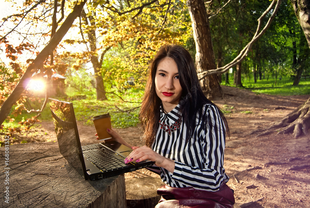 Girl sits with a laptop in the nature Girl sits with a laptop in the nature