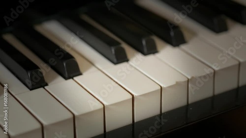 Closeup on piano keys. Camera travel from right to left.
