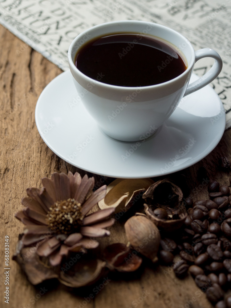 Place the cup on fabric. Wooden table with coffee beans Place the cup on fabric. Wooden table with coffee beans