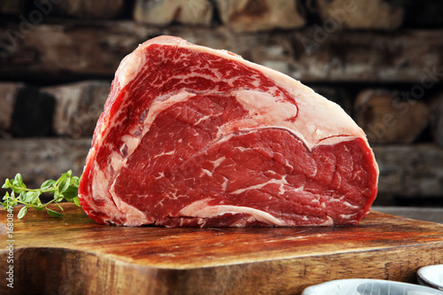 Obraz na plátne Raw fresh meat Ribeye Steak, seasoning and meat fork on dark background