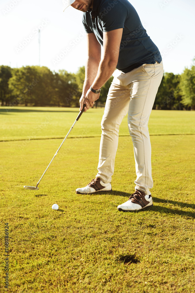 Fototapeta premium Male golfer about to tee off a golf ball