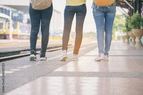 Group of beautiful traveler woman (friends),wearing fashion jeans and sneaker.Close up of feet's backpacker women walking at train station.Travel concept. © prachid