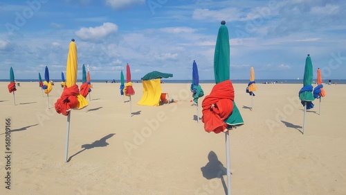 The beach near the boardwalk promenade with the colorful Beach umbrellas at Deauville, Normandy, France
